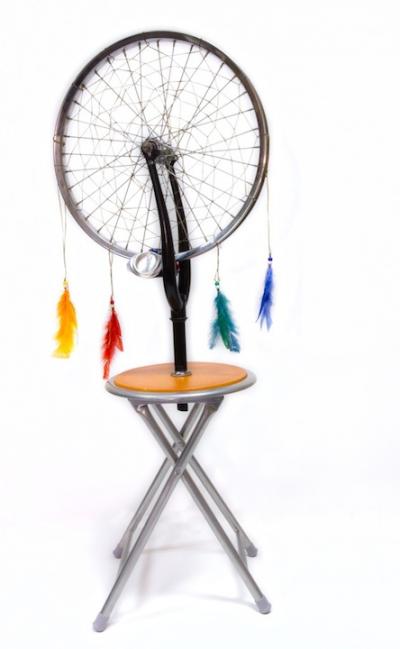 Sculpture of bicyle tire dreamweaver attached to a stool