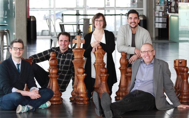 People sitting on a large chess board