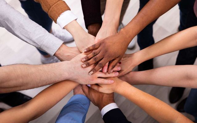 A diverse group of friends stacking hands