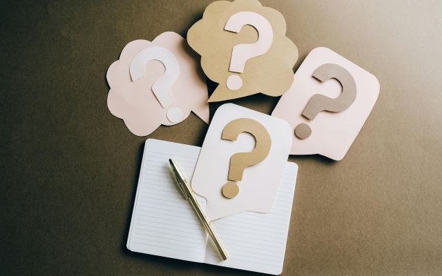 A stock image of question marks and a notebook