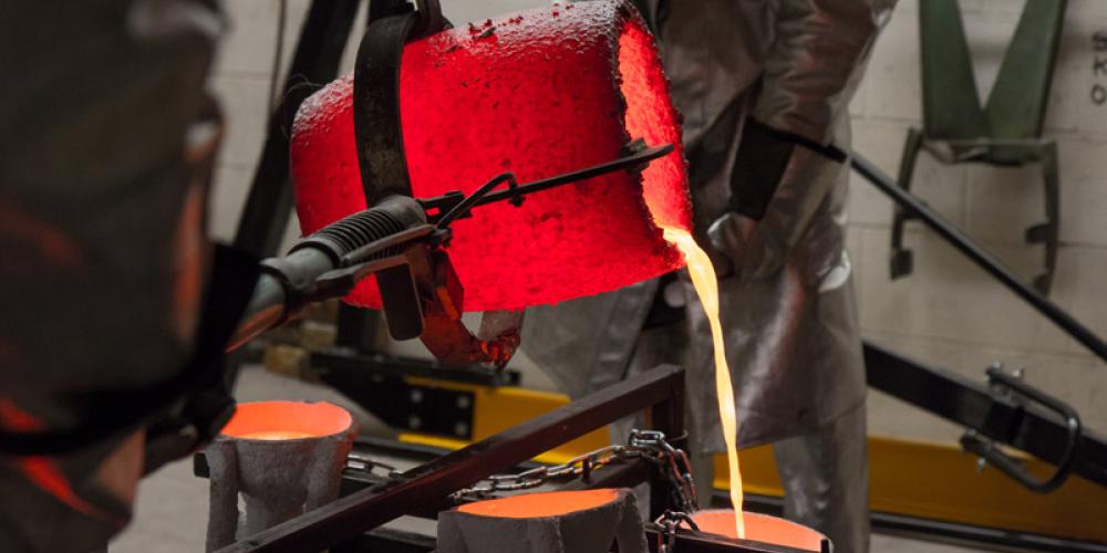 pouring liquid bronze into a cast