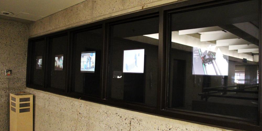 screens that face the hallway to showcase new media student work