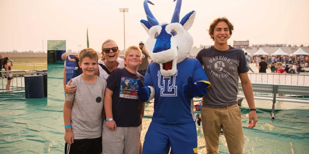 Family hanging out with Luxie, the mascot of uLethbridge