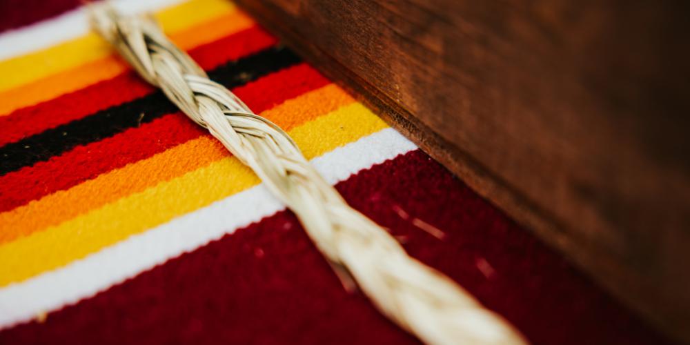 Photo of braid of Sweetgrass next to a smudge box