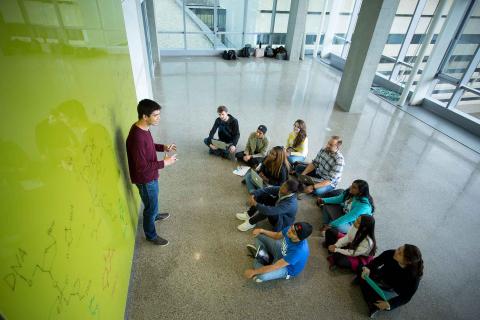 Students in front of green glassboard