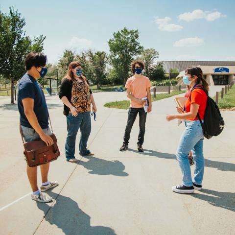 Students standing in physically distanced circle